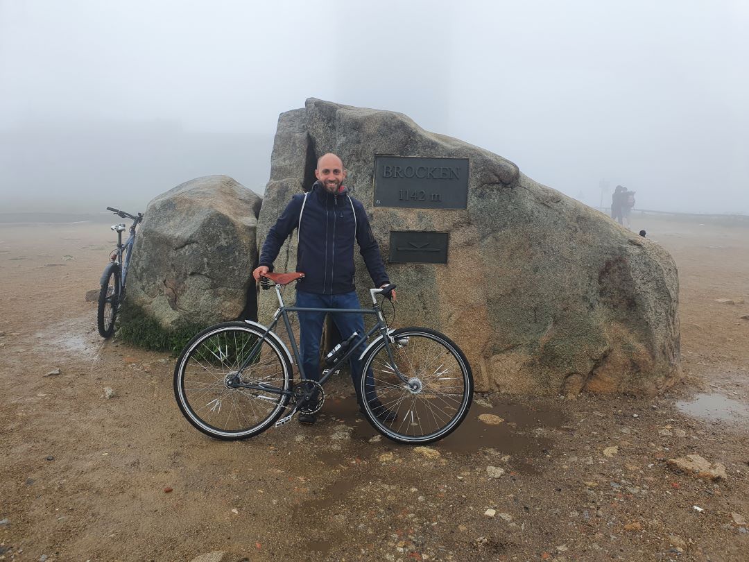 Ich stehe mit meinem Rad auf dem Brocken vor der Höhenmarke = 1142m